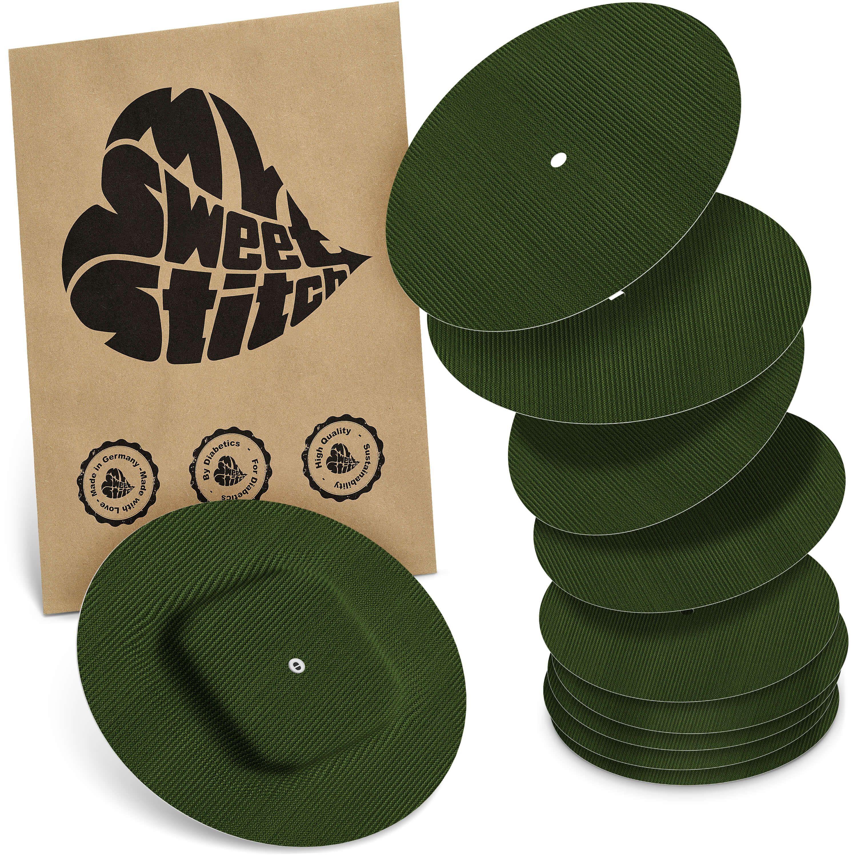 Grüne, runde Pflaster mit geriffelter Oberfläche. Eine Packung mit Logo und Siegeln. Einige Pflaster haben ein Loch.