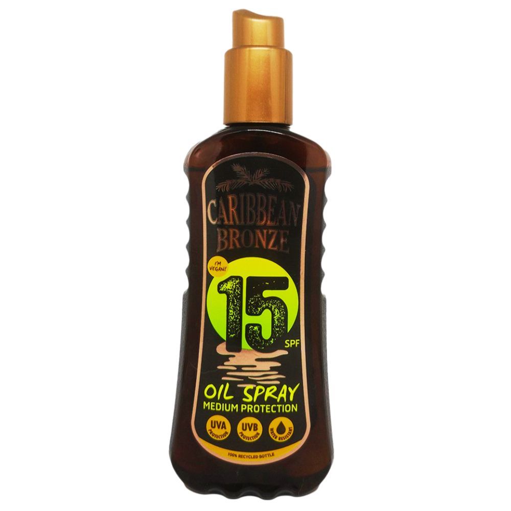 Braune Flasche mit Sprühkopf. Aufschrift: Caribbean Bronze, 15 SPF, Oil Spray, Medium Protection. Mit UVA- und UVB-Symbolen.