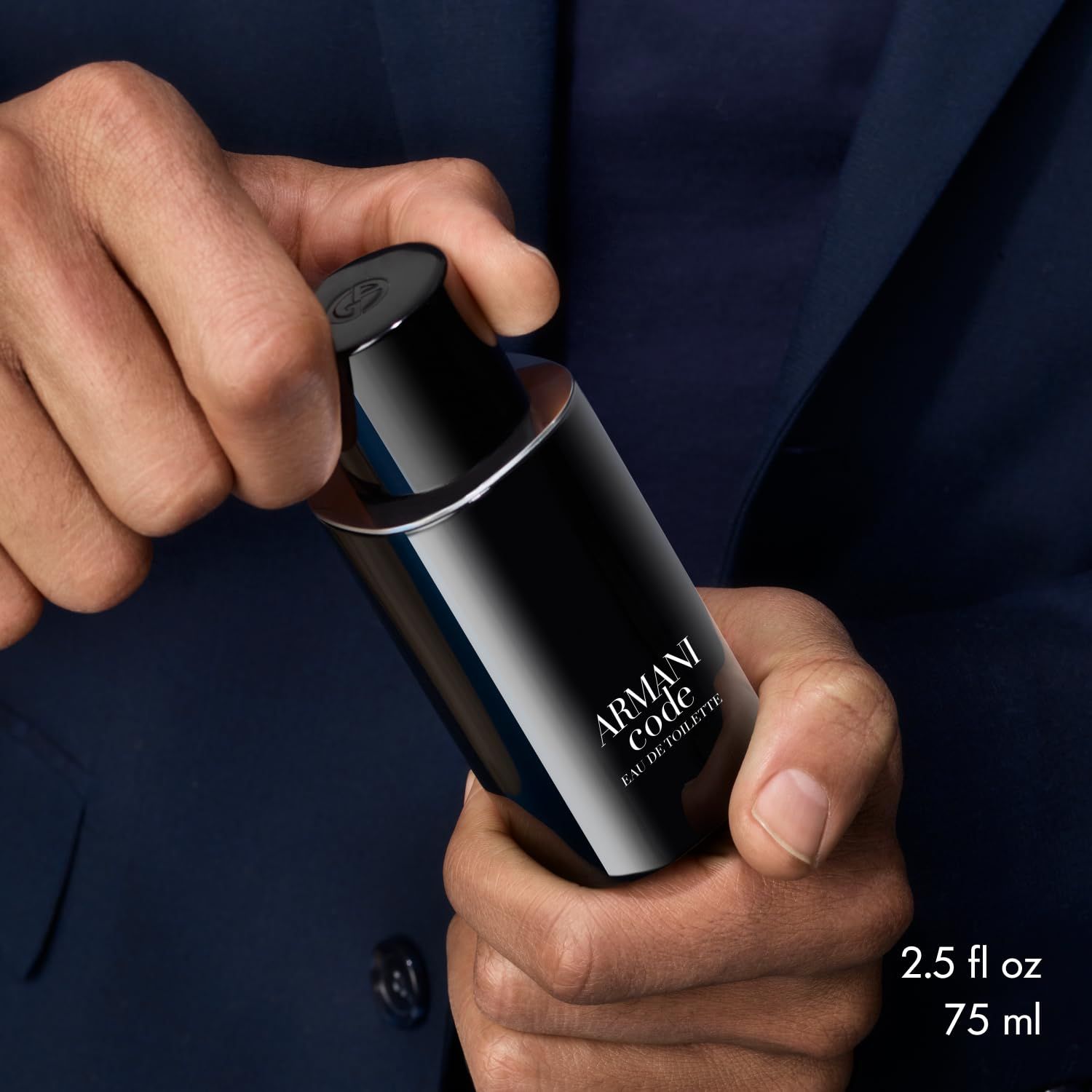 Mann hält einen Armani Code Flakon. Aufschrift: Armani Code Eau de Toilette. 2.5 fl oz.