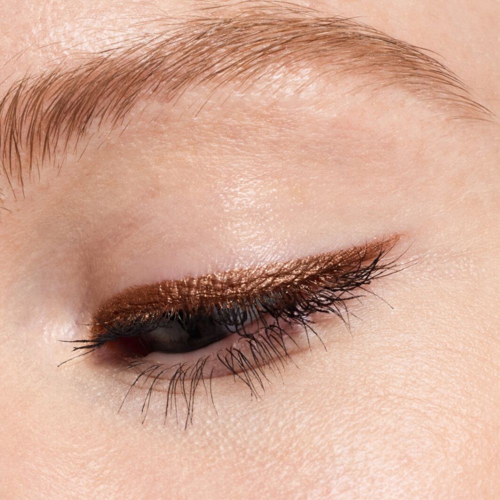 Nahaufnahme eines Auges mit aufgetragenem Augenstift. Braune Farbe.