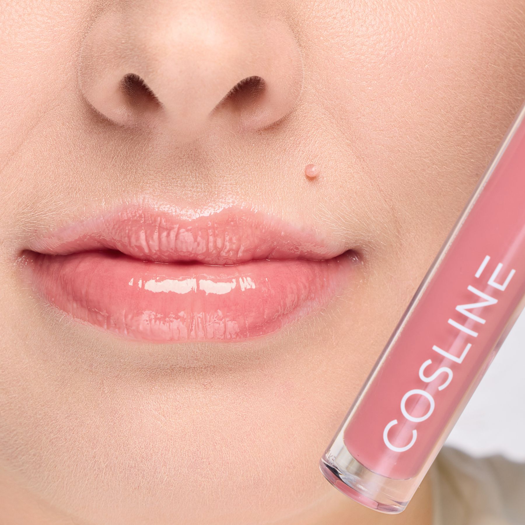 Lippen mit aufgetragenem Lipgloss. Der transparente Behälter zeigt den Inhalt. Der Schriftzug COSline ist sichtbar.