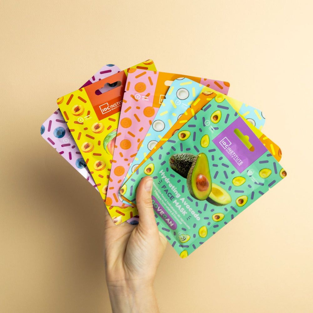 Mehrere Gesichtsmasken in verschiedenen Farben. Hand hält Masken. Marke: IDC Institute. Vegan.