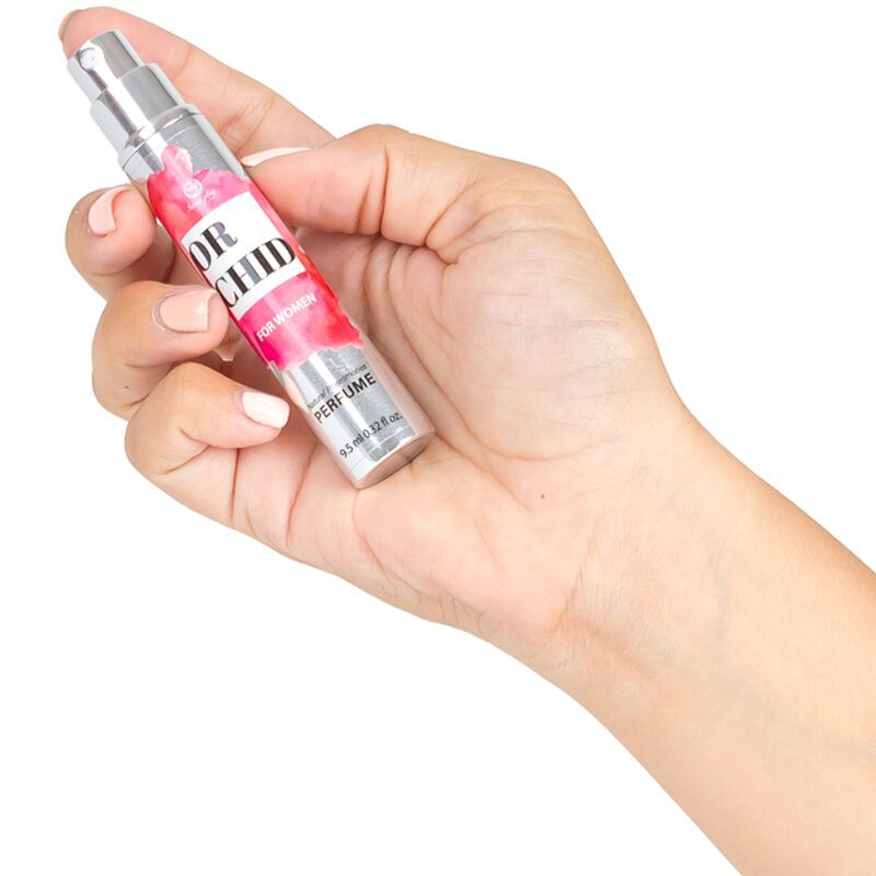 Kleine, zylindrische Flasche mit Aufschrift "ORCHID FOR WOMEN". Die Flasche wird von einer Hand gehalten.