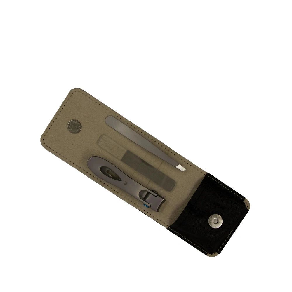 Etui mit drei Nagelpflege-Werkzeugen. Enthält Nagelschere, Feile und Pinzette. Beige-schwarzes Etui mit Druckknopfverschluss.