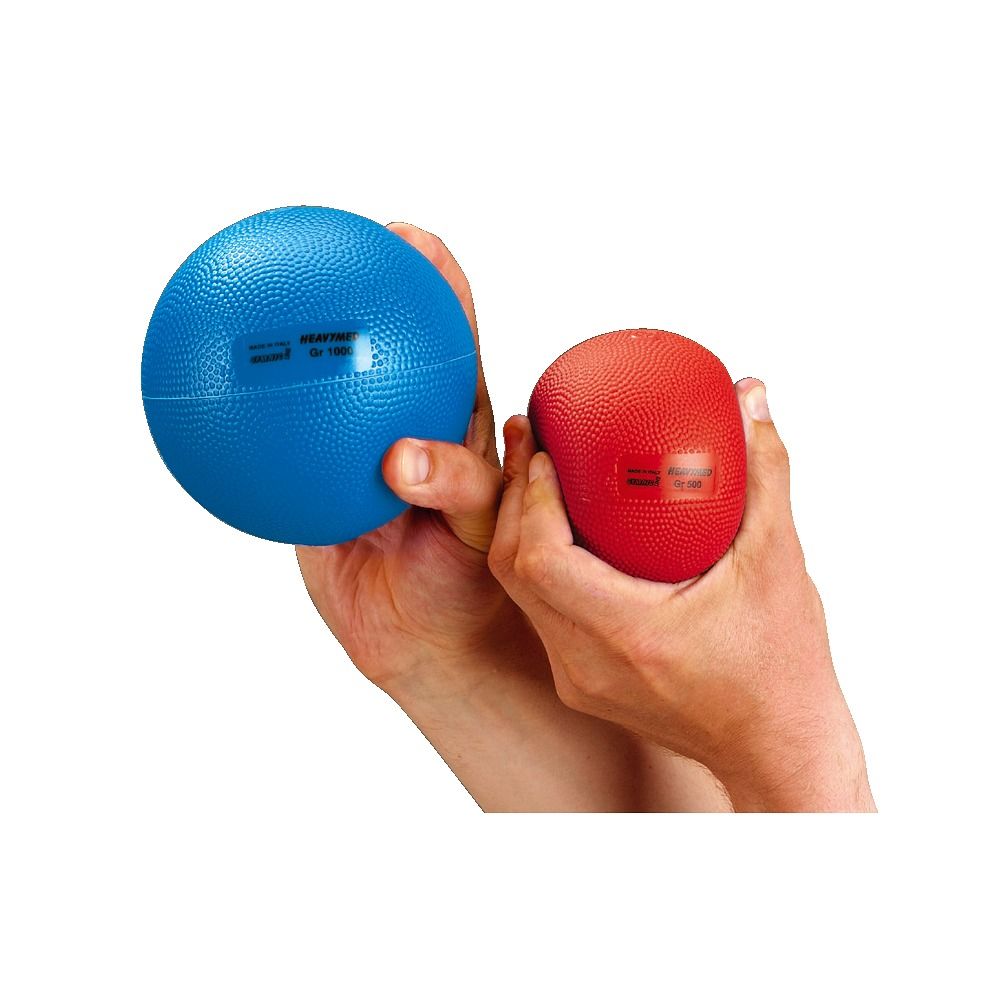 Zwei Gymnic Heavymed Gewichtsballen in Händen. Blau und rot. Aufkleber sichtbar. Noppenstruktur.