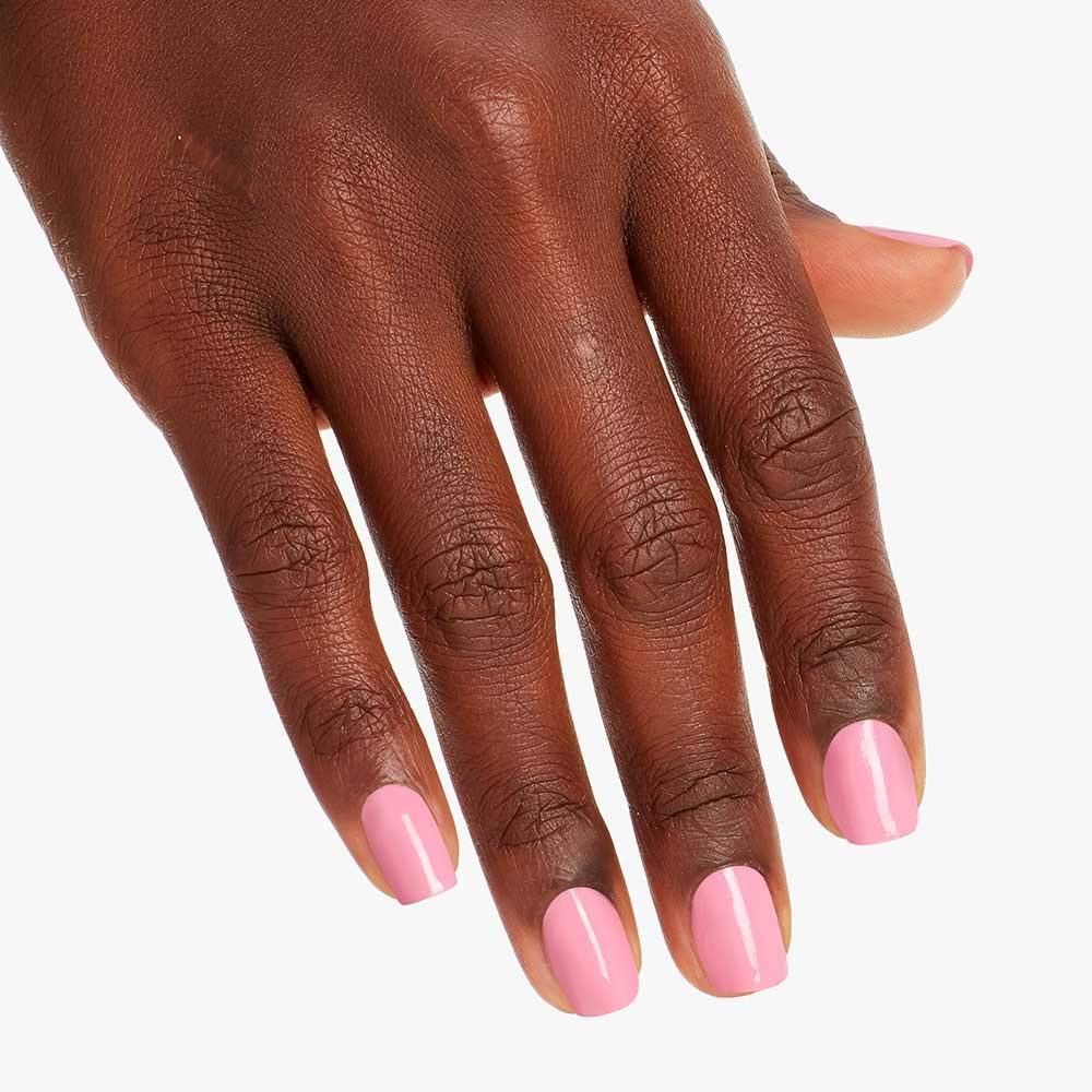 Hand mit lackierten Nägeln. Rosa Nagellack auf den Fingernägeln.