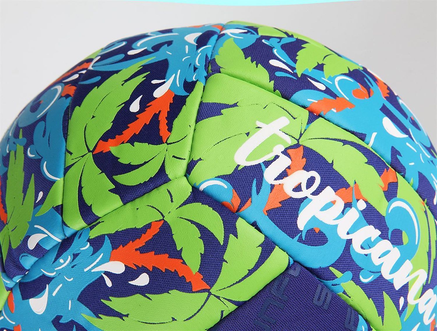 Detailaufnahme eines Beachballs mit tropischem Muster und Aufschrift "tropicana".