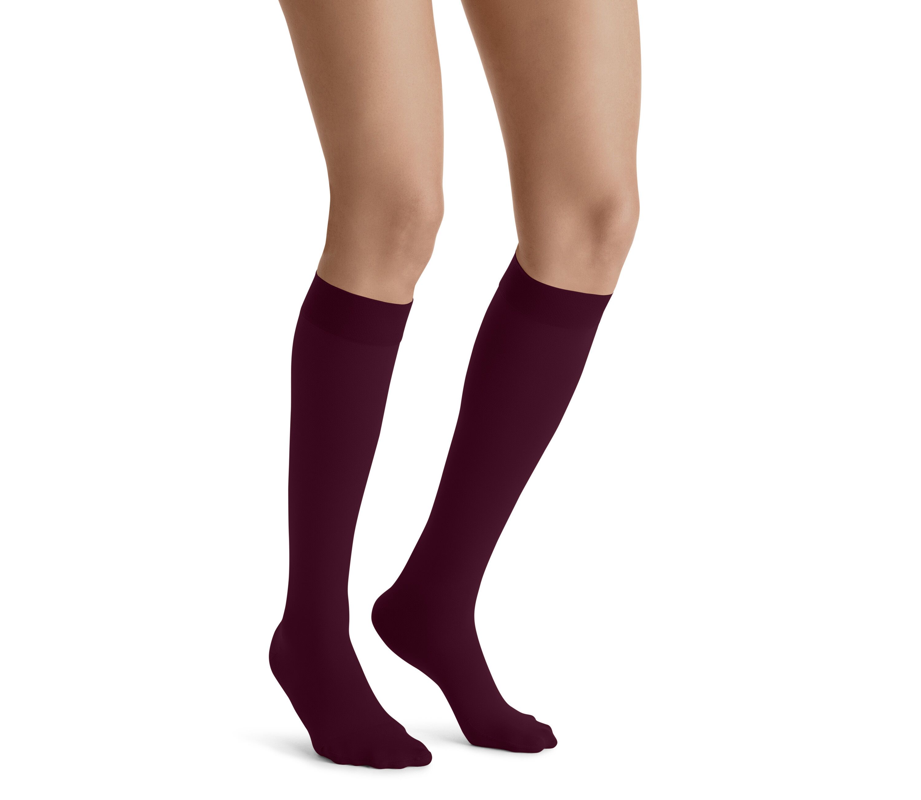 Beine mit JOBST UltraSheer Kompressions-Kniestrümpfen in Burgunderrot. Nahaufnahme, weißer Hintergrund.