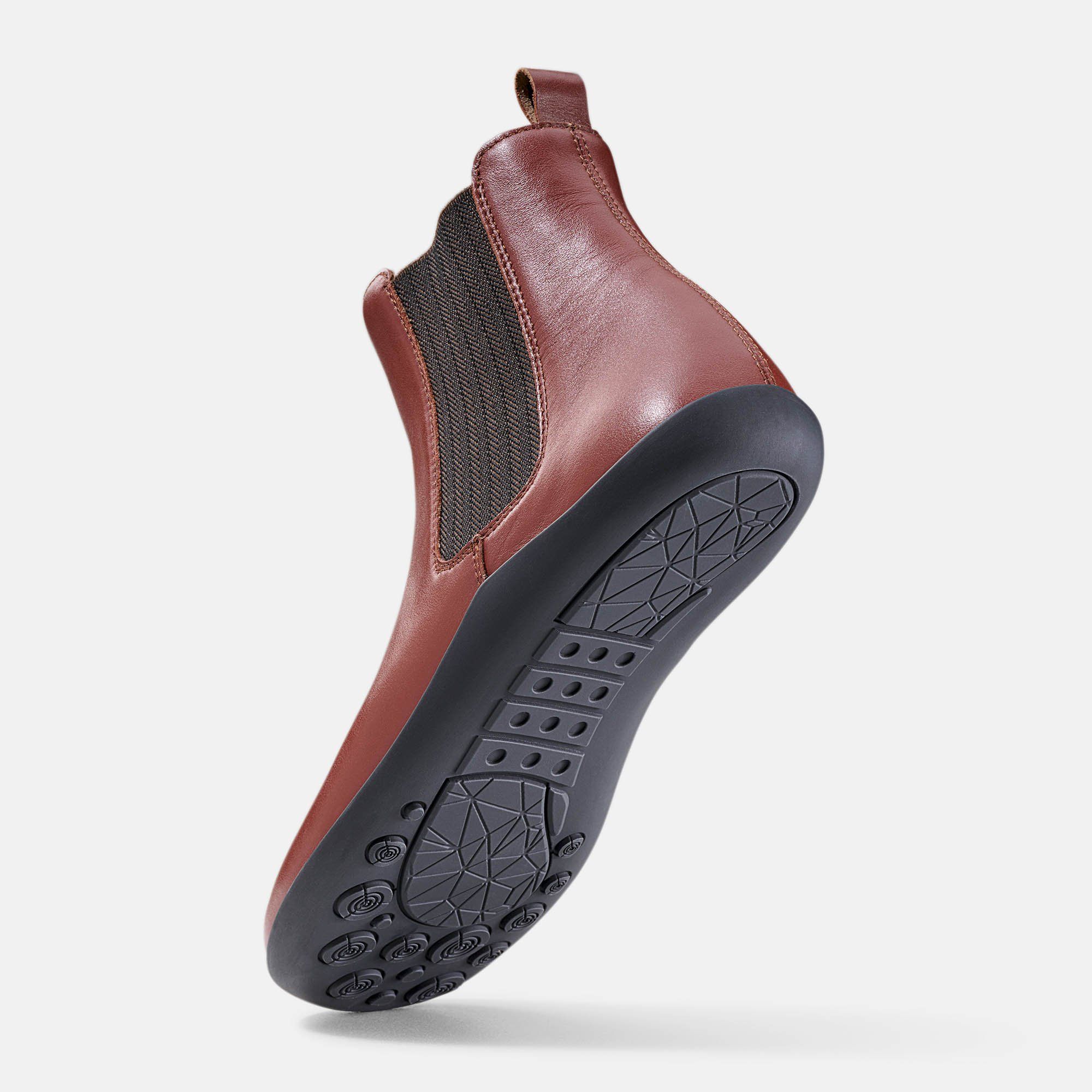 Rötlich-braune Stiefelette. Schwarze Sohle mit Muster. Zuglasche. Elastischer Einsatz. Profilierte Sohle.