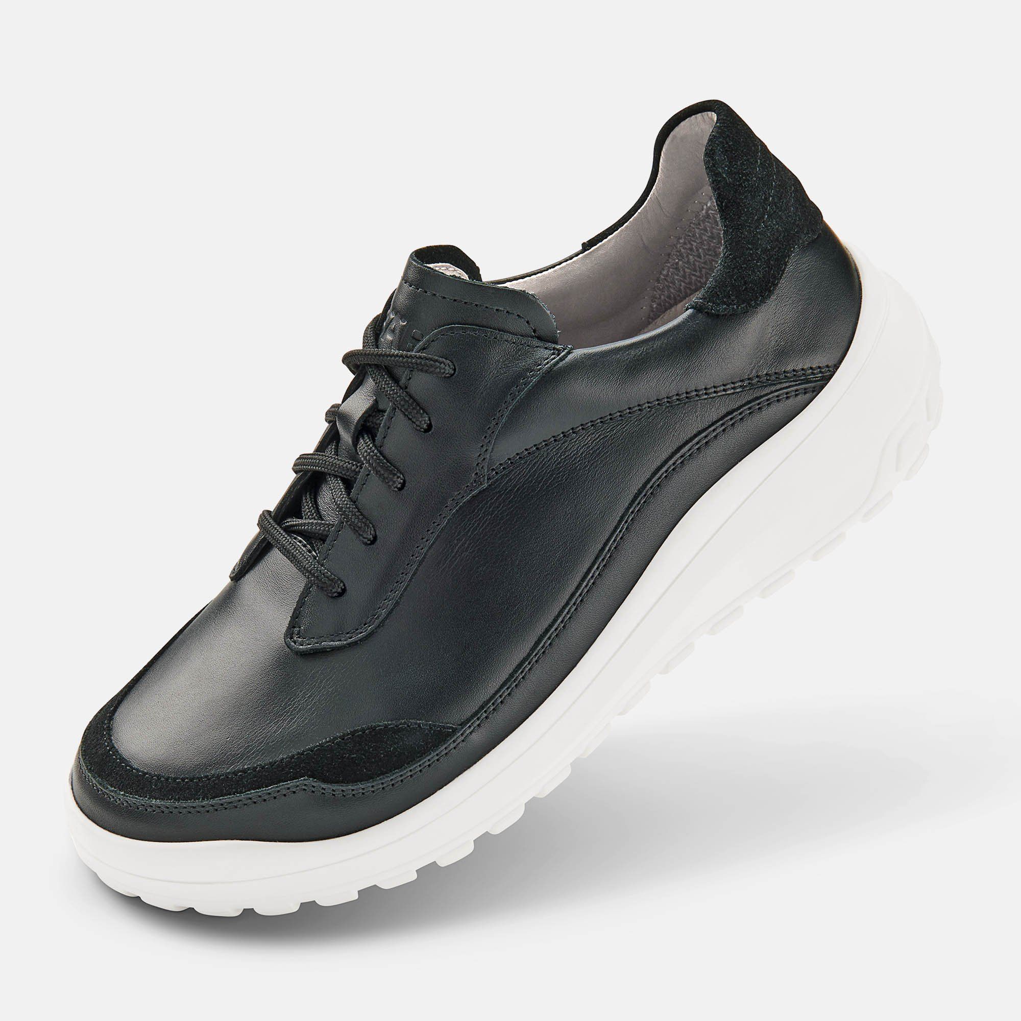 Schwarzer Schnürschuh mit weißer Sohle. Leder-Obermaterial, breite Passform. Schwarze Schnürsenkel.