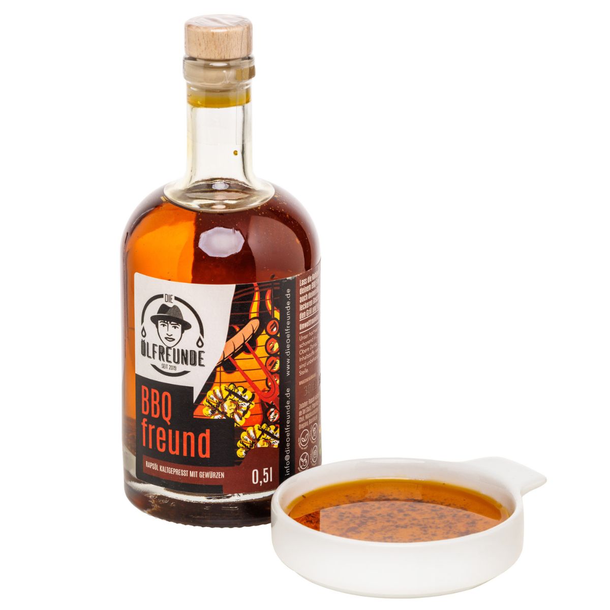 Glasflasche mit brauner Flüssigkeit und Holzverschluss, neben einer weißen Schale mit Flüssigkeit.