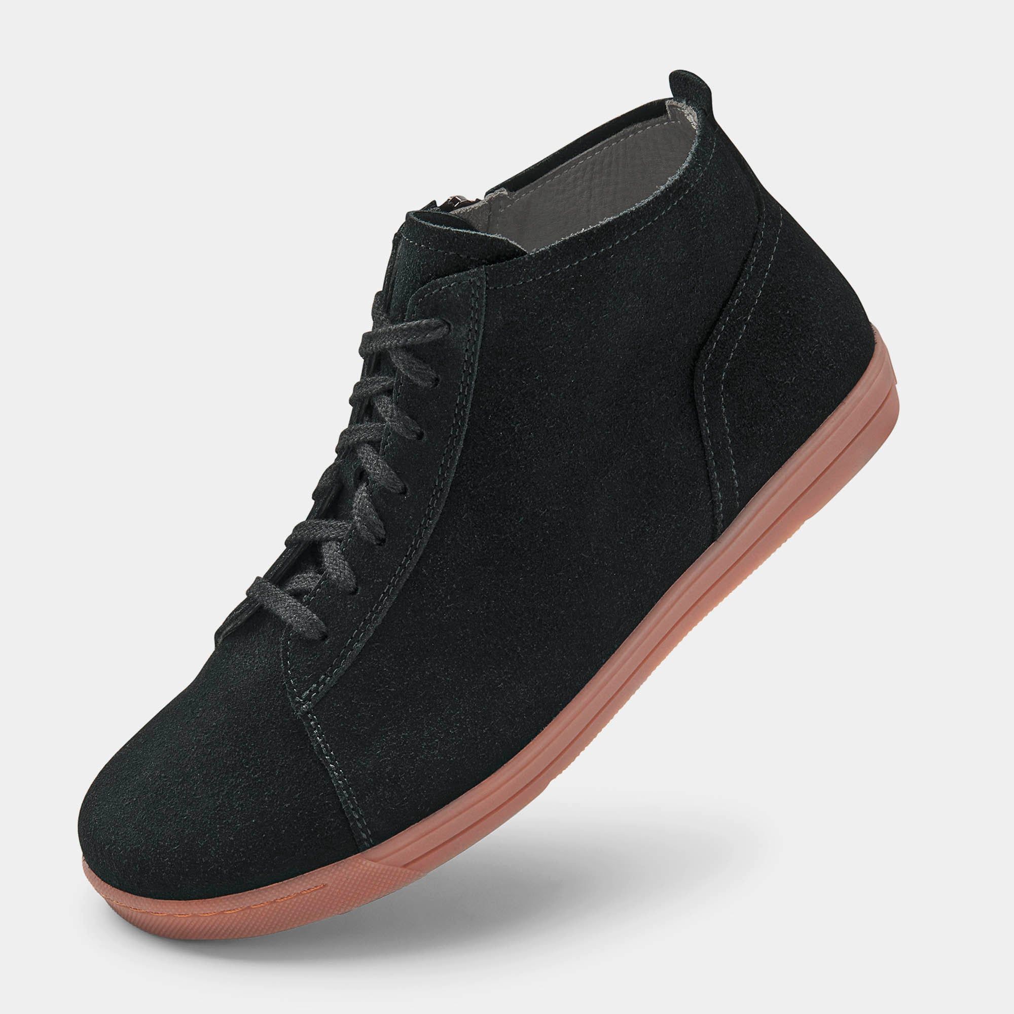 Schwarze Stiefelette mit Schnürsenkeln und Reißverschluss. Rosa Sohle. Hellgrauer Hintergrund.