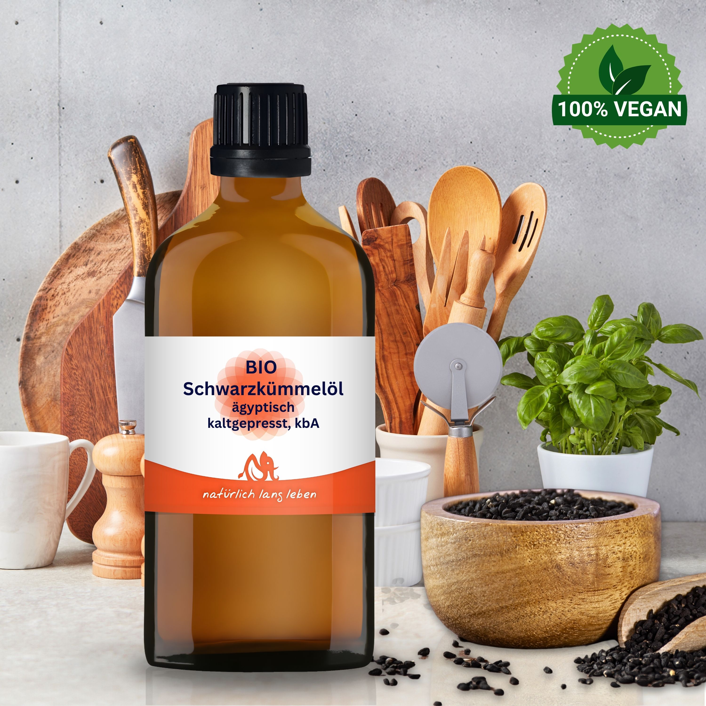 Braune Glasflasche mit BIO Schwarzkümmelöl. Schwarze Kappe. Label mit Produktinformationen. 100% vegan Siegel. Schwarze Samen in Schale.