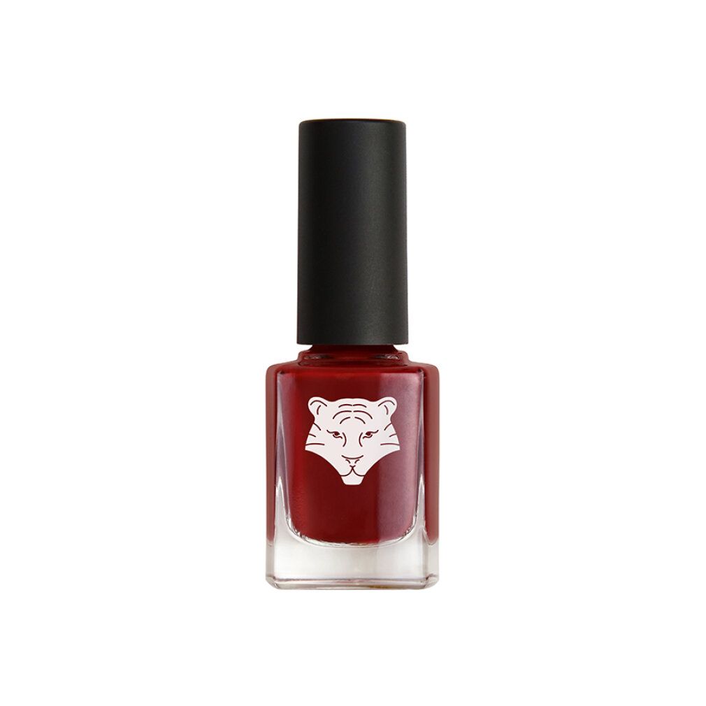 Nagellackflasche mit Tigerlogo. Roter Nagellack in einer quadratischen Glasflasche mit schwarzem Deckel.