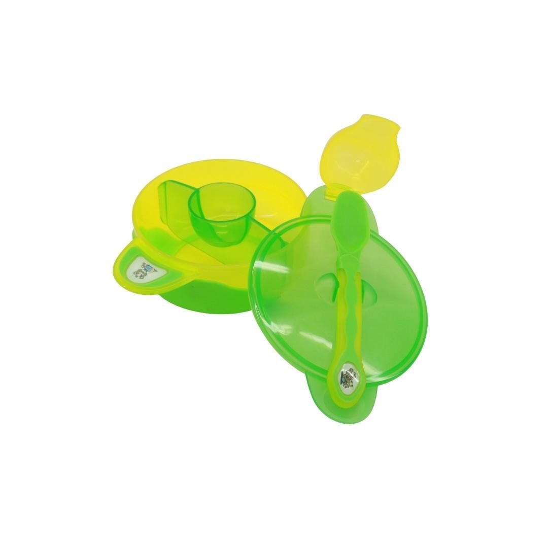 Baby-Set mit Schüssel, Deckel und Löffel. Der Deckel ist geöffnet. Die Schüssel ist gelb und grün. Der Löffel ist grün.