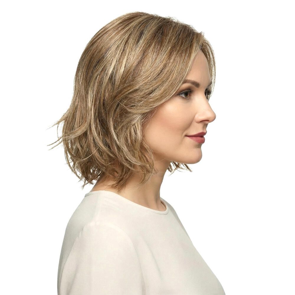 Perücke Lilie von trendhair. Kurze, gewellte Kunsthaarperücke in Blond- und Brauntönen. Seitenansicht einer Frau.