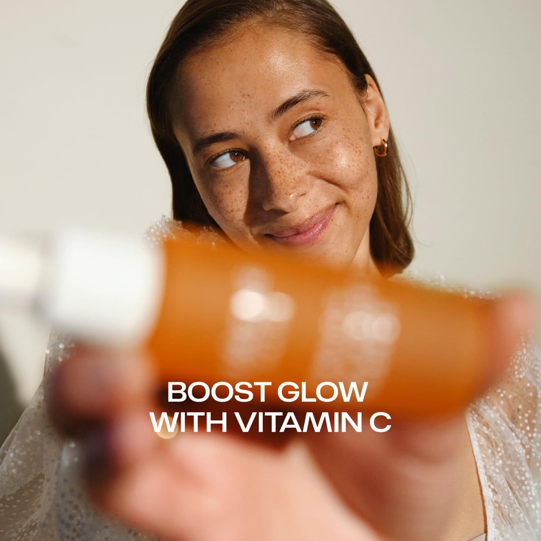 Frau hält Lumene Flasche mit Text 'BOOST GLOW WITH VITAMIN C'.