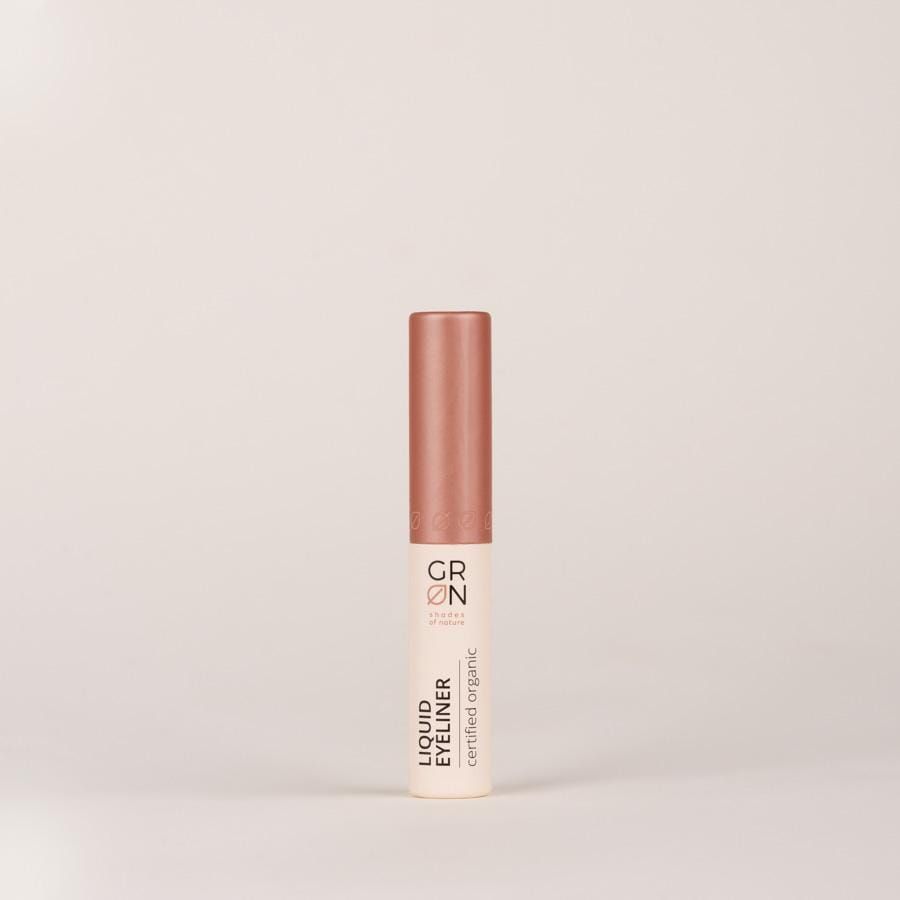 Geschlossene Flasche flüssigen Eyeliners. Aufschrift: GRN, Liquid Eyeliner, certified organic. Rosa-goldener Deckel.