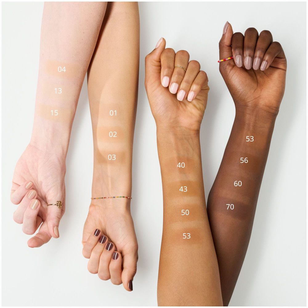 Arme mit Foundation-Farbtönen. Verschiedene Hauttöne mit Foundation-Farben beschriftet. Farbnummern: 01, 02, 03, 04, 13, 15, 40, 43, 50, 53, 56, 60, 70.