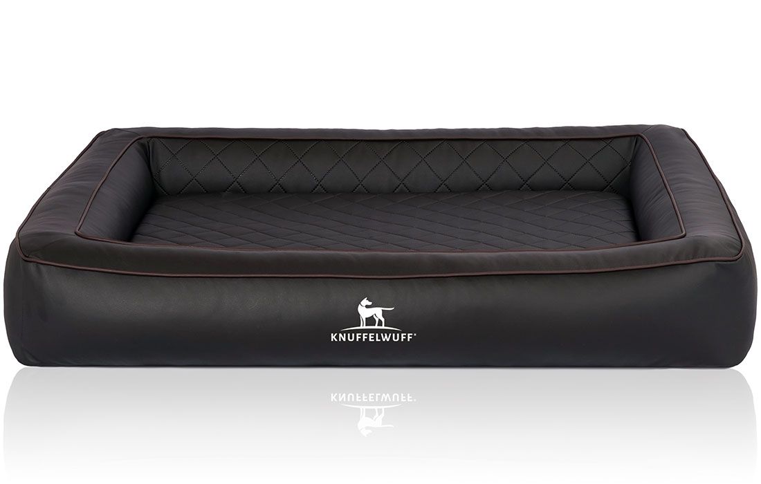 Orthopädisches Hundebett Hampstead. Schwarzes, rechteckiges Bett mit erhöhten Rändern und gesteppter Liegefläche. Knuffelwuff Logo.