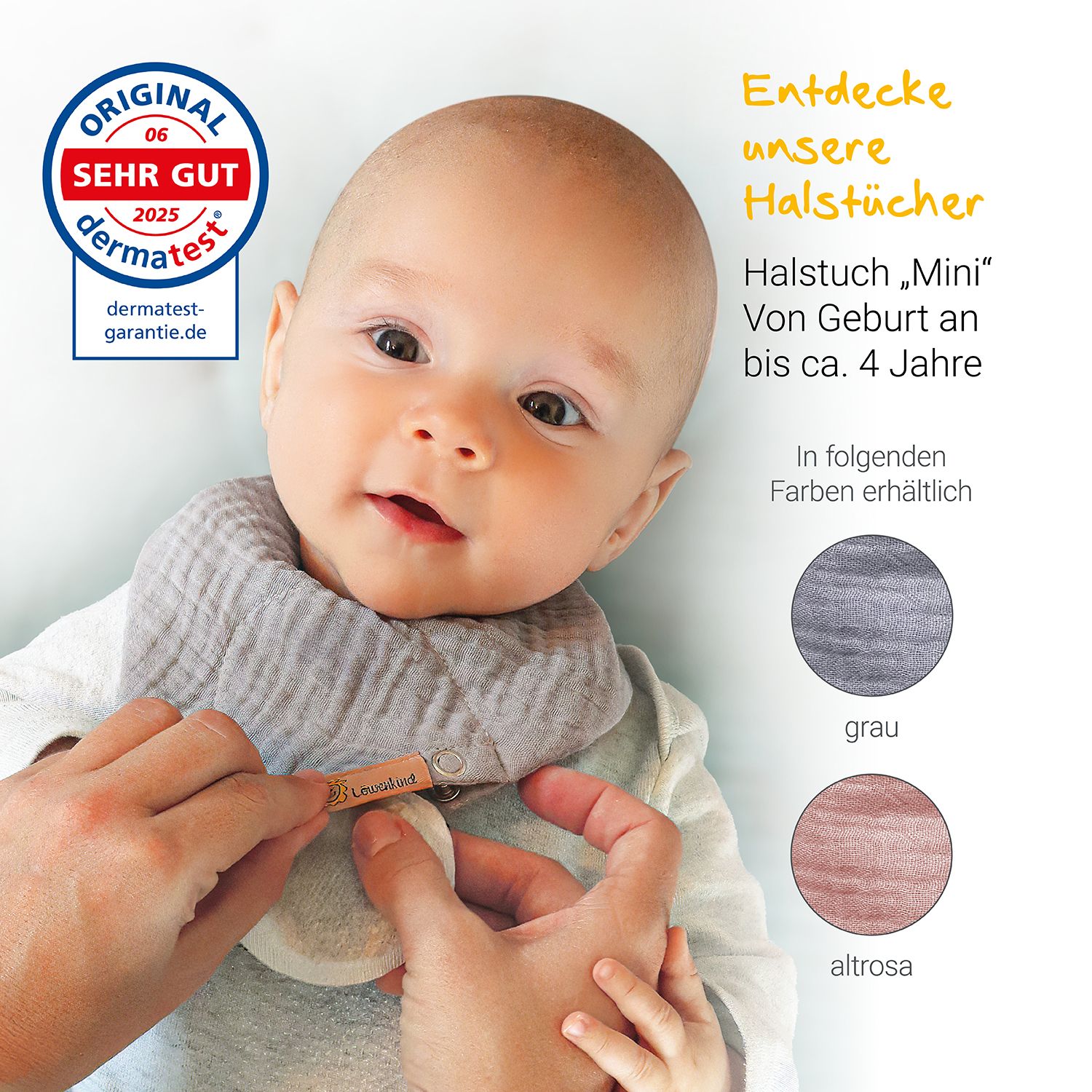 Baby mit Halstuch. Label: LÖWENKIND. Text: Halstuch „Mini“. Farben: grau, altrosa. Dermatest-Siegel.
