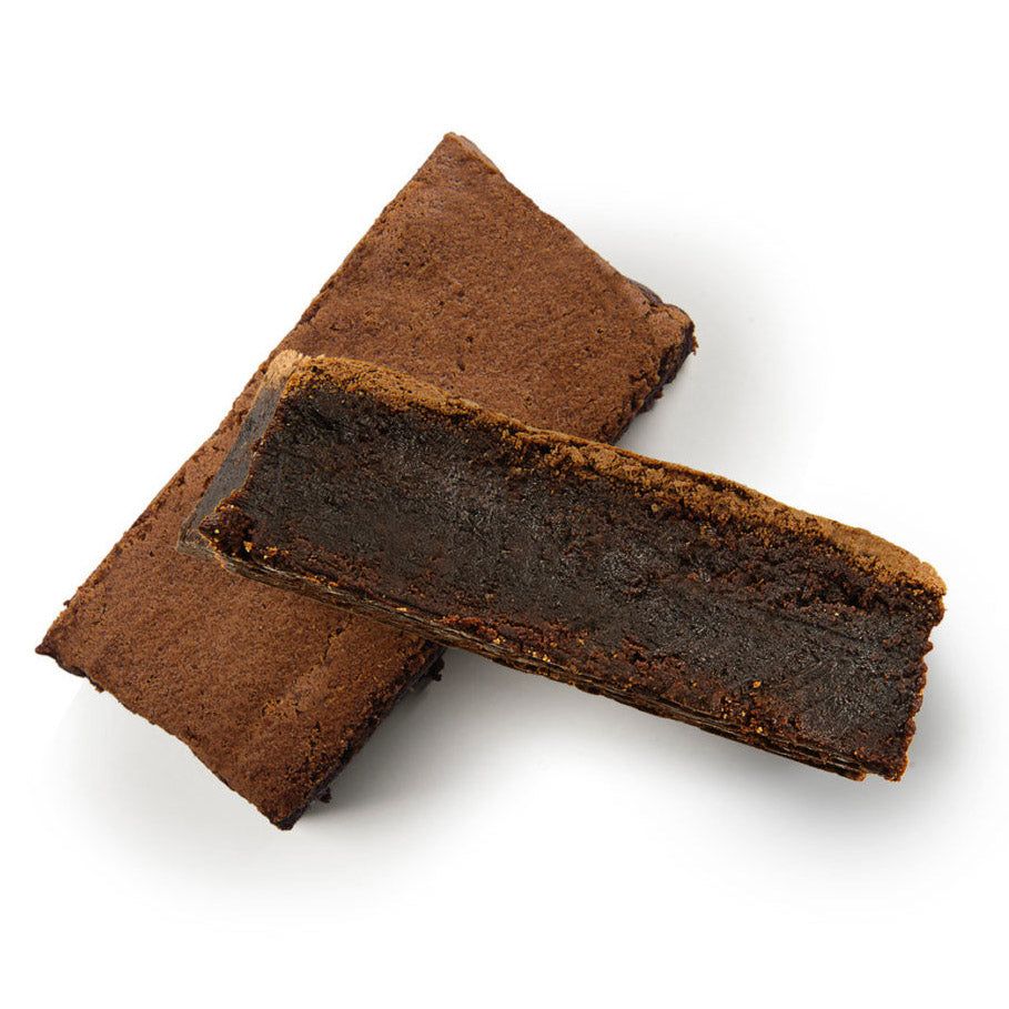 Zwei braune Kuchenstücke auf weißem Hintergrund. Sichtbare Schnittfläche.