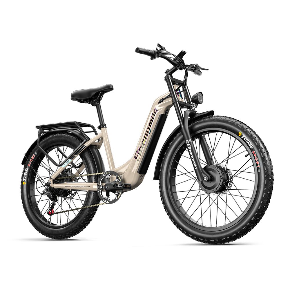 E-Bike, diagonale Ansicht. Beige Rahmen, schwarze Reifen. Marke Shengmilo sichtbar. Gepäckträger und Schutzbleche.