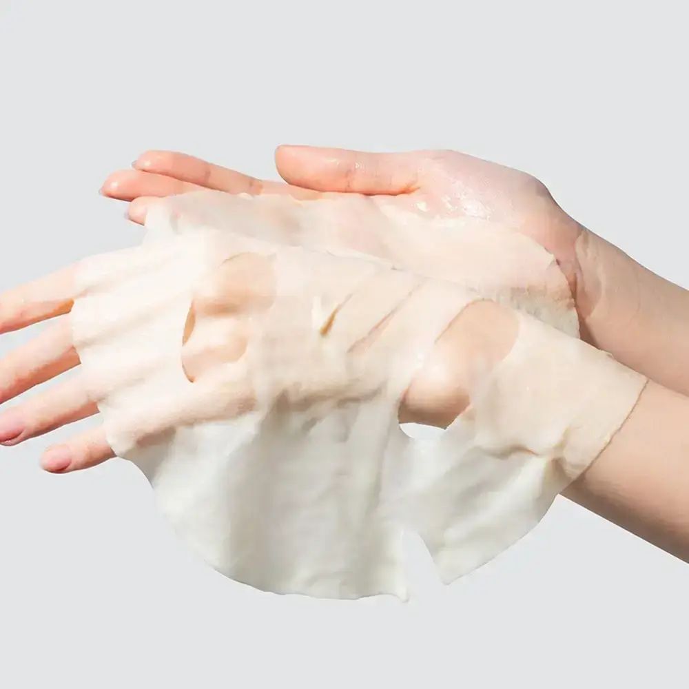 Gesichtsmaske in Händen. Maske mit Aussparungen für Augen und Mund. Helle, transparente Textur.