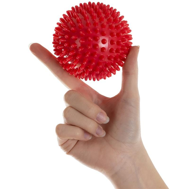 Roter Massageball mit Noppen in Hand gehalten.