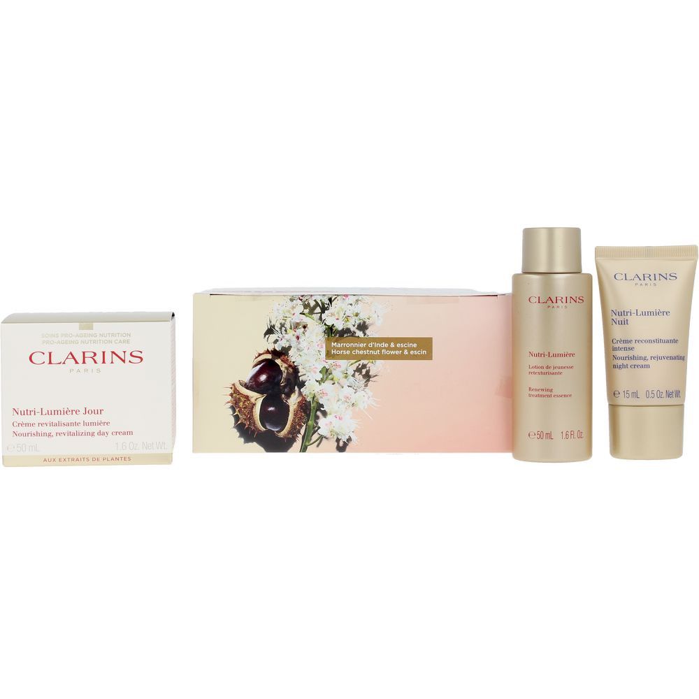 Geschenkset mit Tagescreme, Nachtcreme und Serum. Verpackung mit floralem Design und Kastanien. Produkte mit goldfarbenen Details.