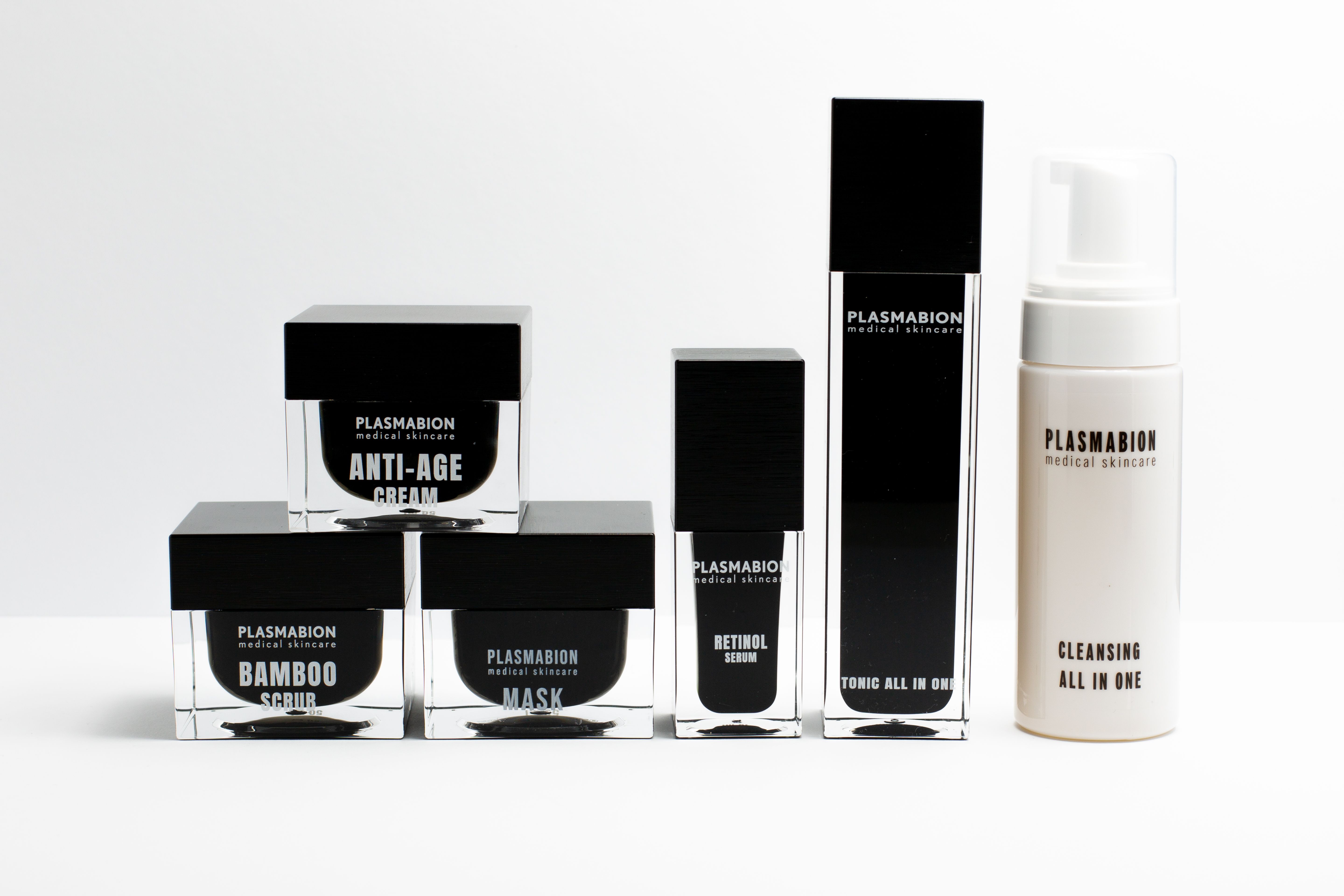 Mehrere Produkte: Flakons und Tiegel. Aufschrift: PLASMABION, ANTI-AGE CREAM, SCRUB, MASK, RETINOL SERUM, TONIC ALL IN ONE, CLEANSING ALL IN ONE.