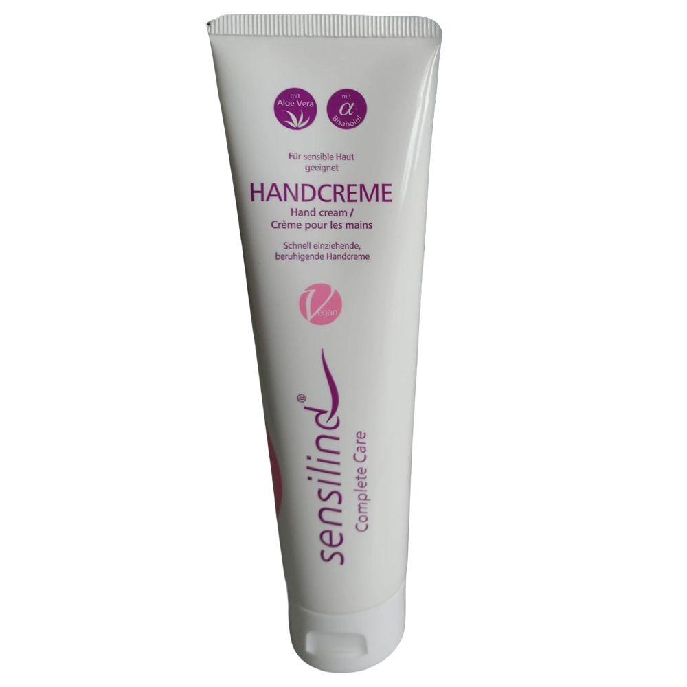 Weiße Tube mit lila Schriftzug. Beschriftung: HANDCREME, Sensilind Complete Care. Logos: Aloe Vera, Alpha-Symbol, V-Symbol.