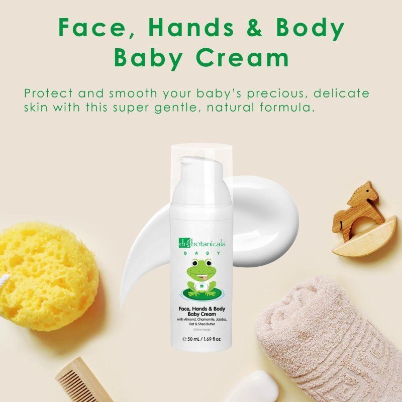 Dr. Botanicals Babycreme mit Frosch-Motiv, umgeben von Baby-Pflegeprodukten und Spielzeug.