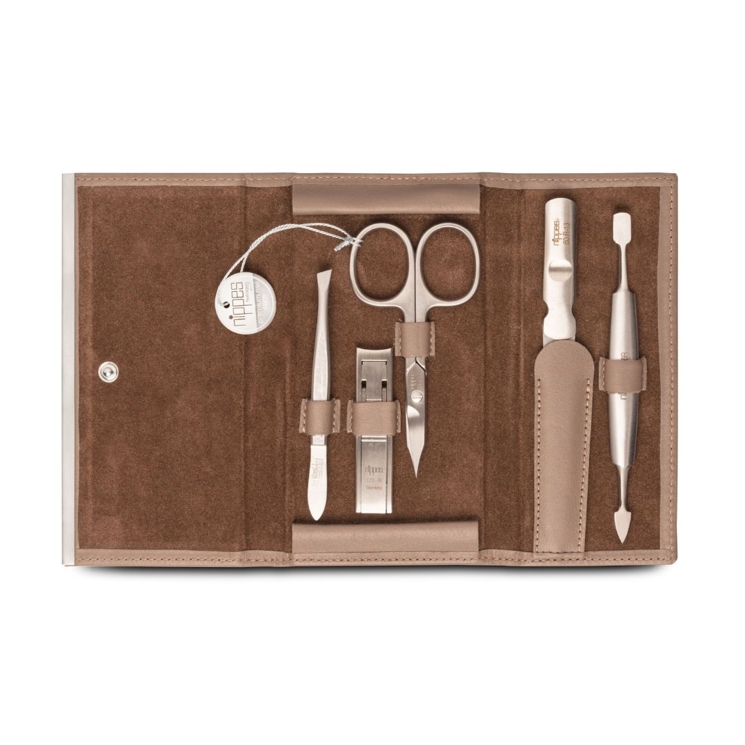 Maniküre-Etui DOVE, geöffnet. Enthält Nagelschere, Pinzette, Nagelknipser und weitere Werkzeuge. Beige Lederoptik.