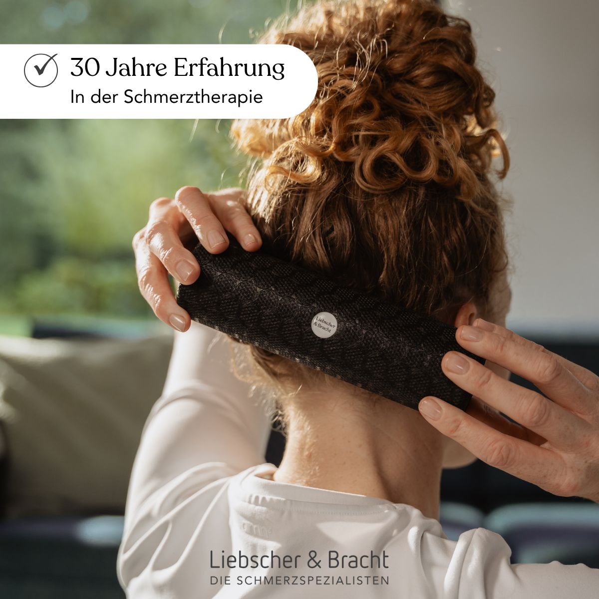 Frau massiert ihren Nacken mit einer schwarzen Liebscher & Bracht Rolle.