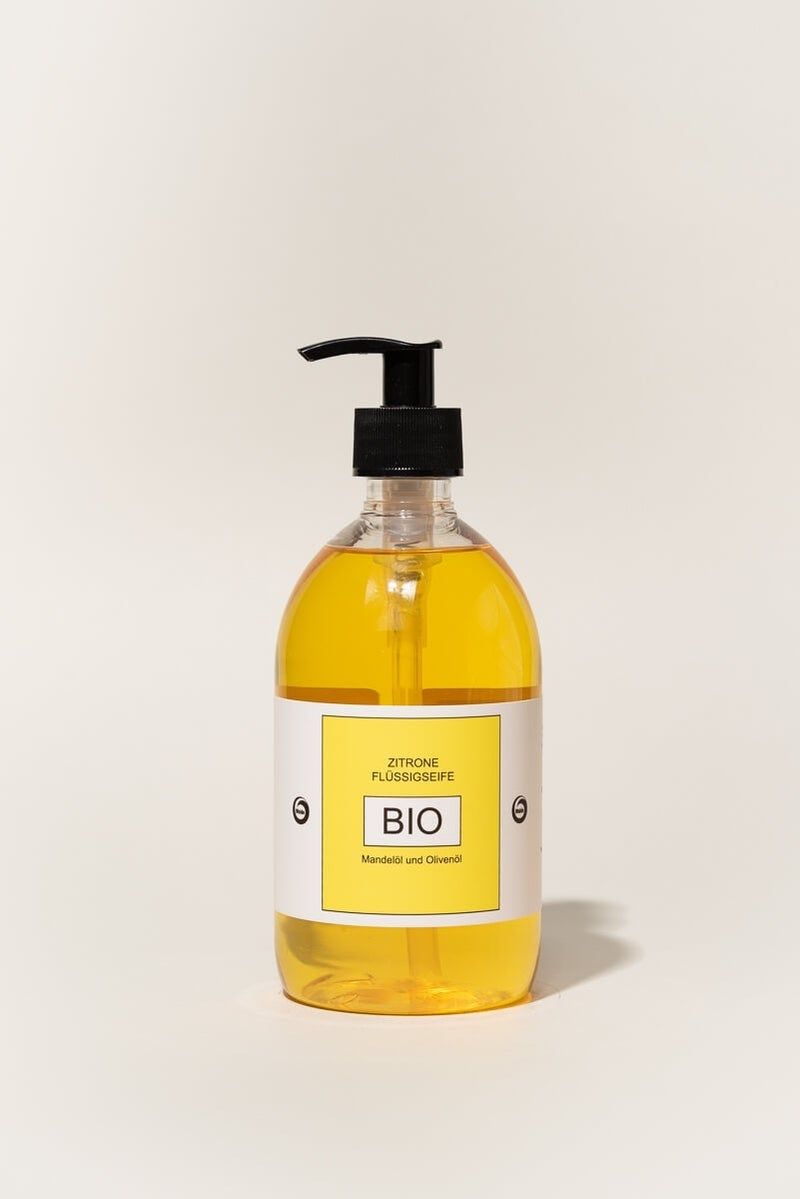 Gelbe Flüssigseife in einer transparenten Flasche mit schwarzem Spender. Auf dem Etikett steht BIO und Zitrone.