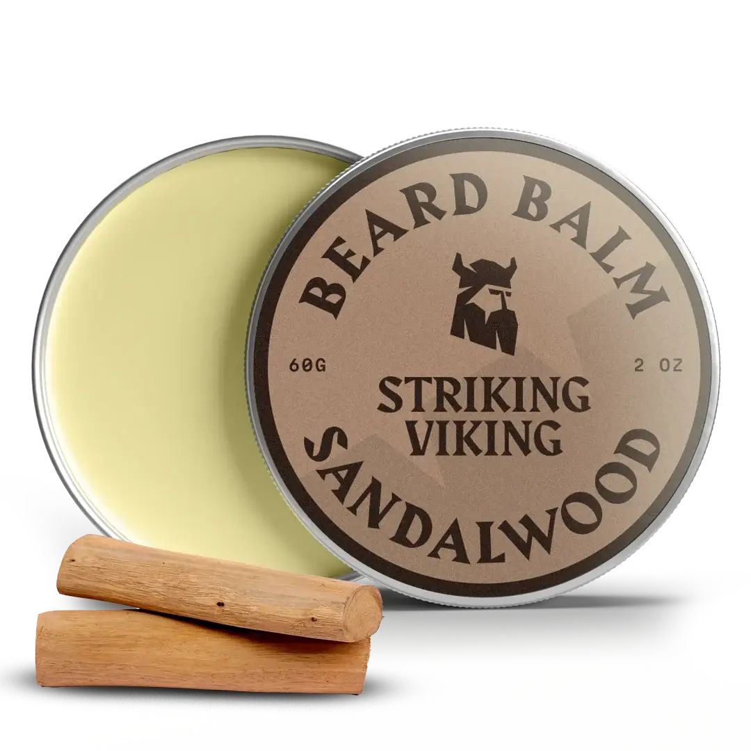 Offene Dose Bartbalsam. Deckel mit Aufschrift: BEARD BALM, STRIKING VIKING, SANDALWOOD. Zwei Holzstücke daneben.