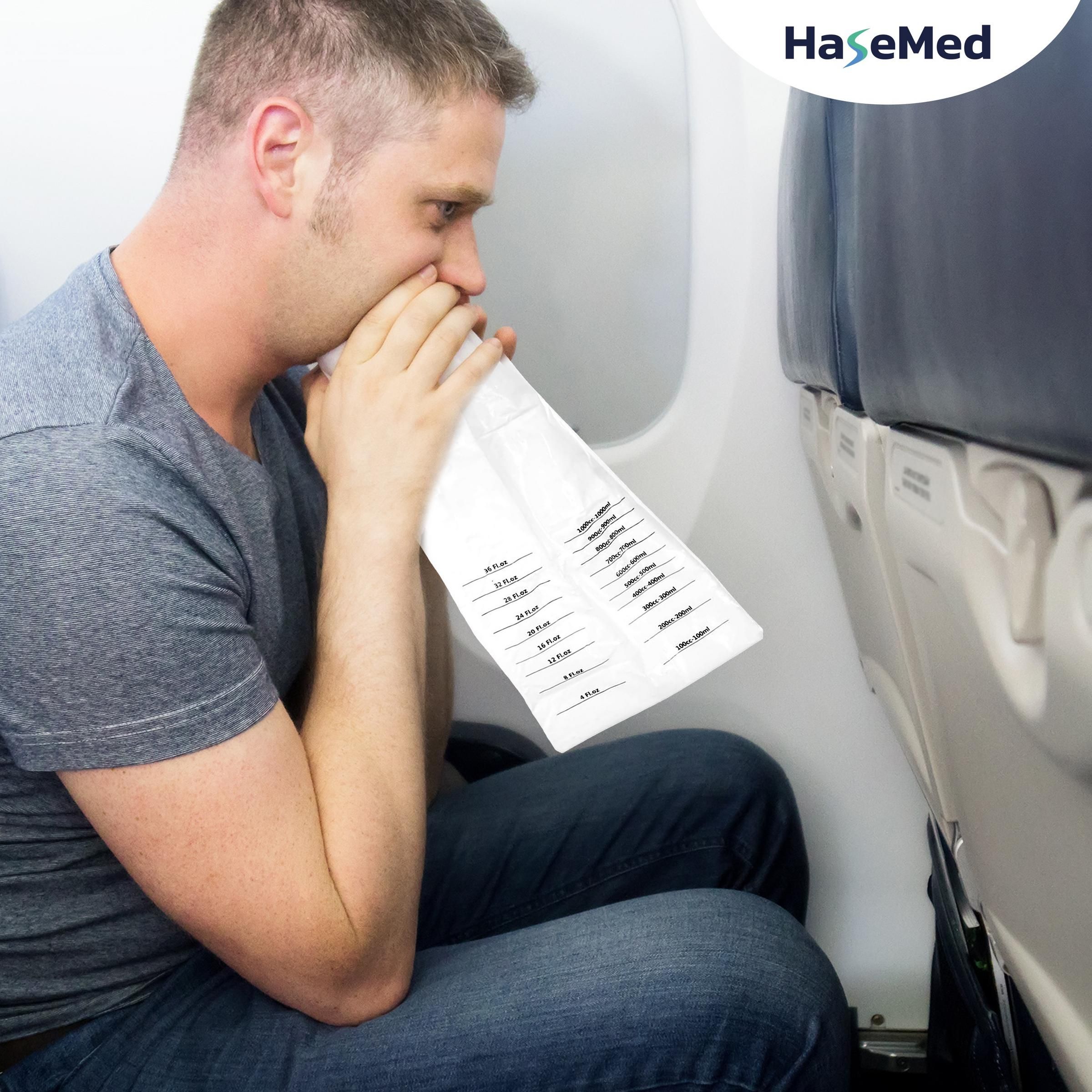 Mann im Flugzeug benutzt einen Spuckbeutel. Marke HaseMed ist sichtbar.