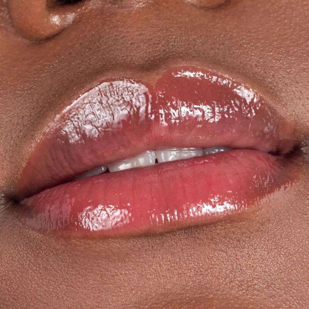Nahaufnahme von vollen Lippen mit glänzendem, rosafarbenem Lipgloss.