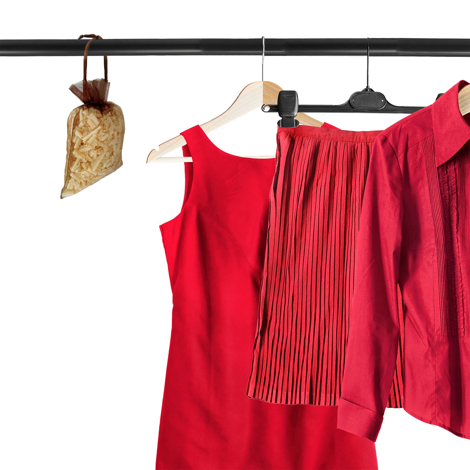 Braunes Duftsackerl hängt an Kleiderstange neben roter Kleidung. Holzflocken sichtbar.