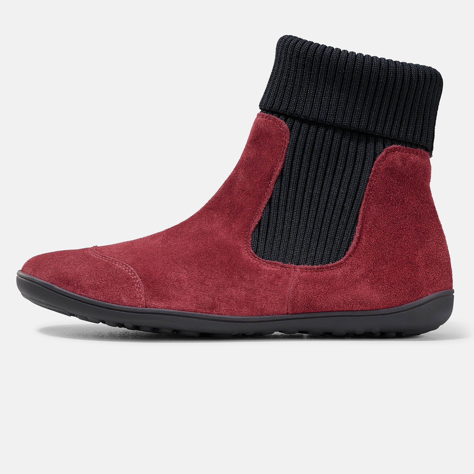 Rote Stiefelette mit schwarzem, geripptem Schaft. Flache Sohle. Obermaterial aus Wildleder. Seitenansicht.