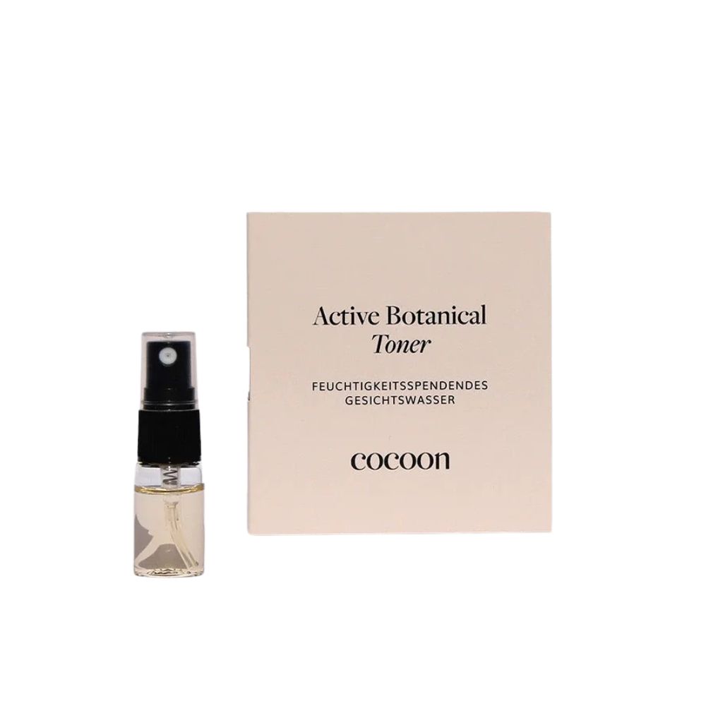 Kleines Sprühfläschchen und Karton. Auf dem Karton steht "Active Botanical Toner", "Feuchtigkeitsspendendes Gesichtswasser" und "cocoon".
