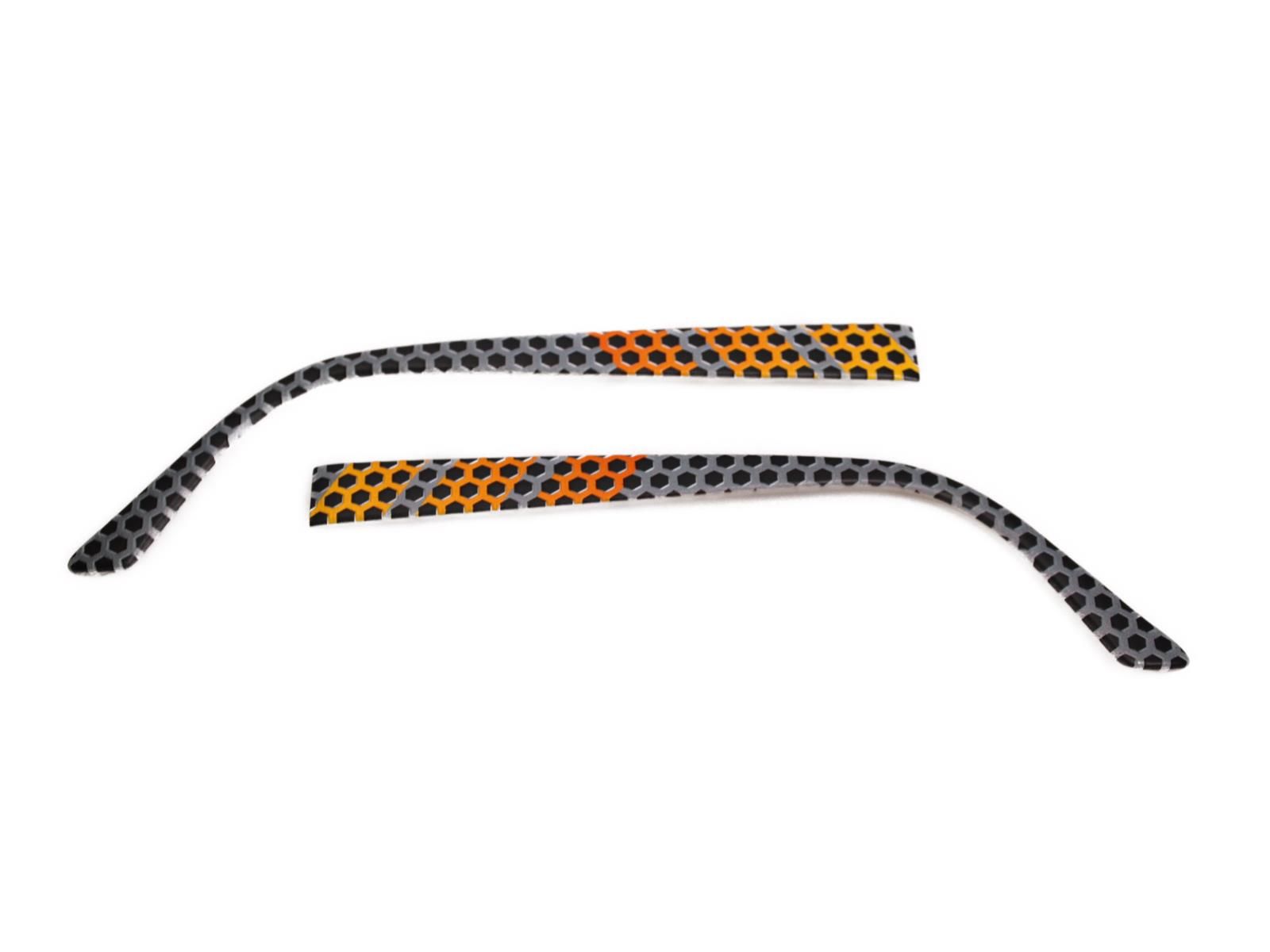 Zwei Wechselbügel für Brillen. Graue, orange und gelbe Muster mit kleinen Löchern. Gebogene Form.