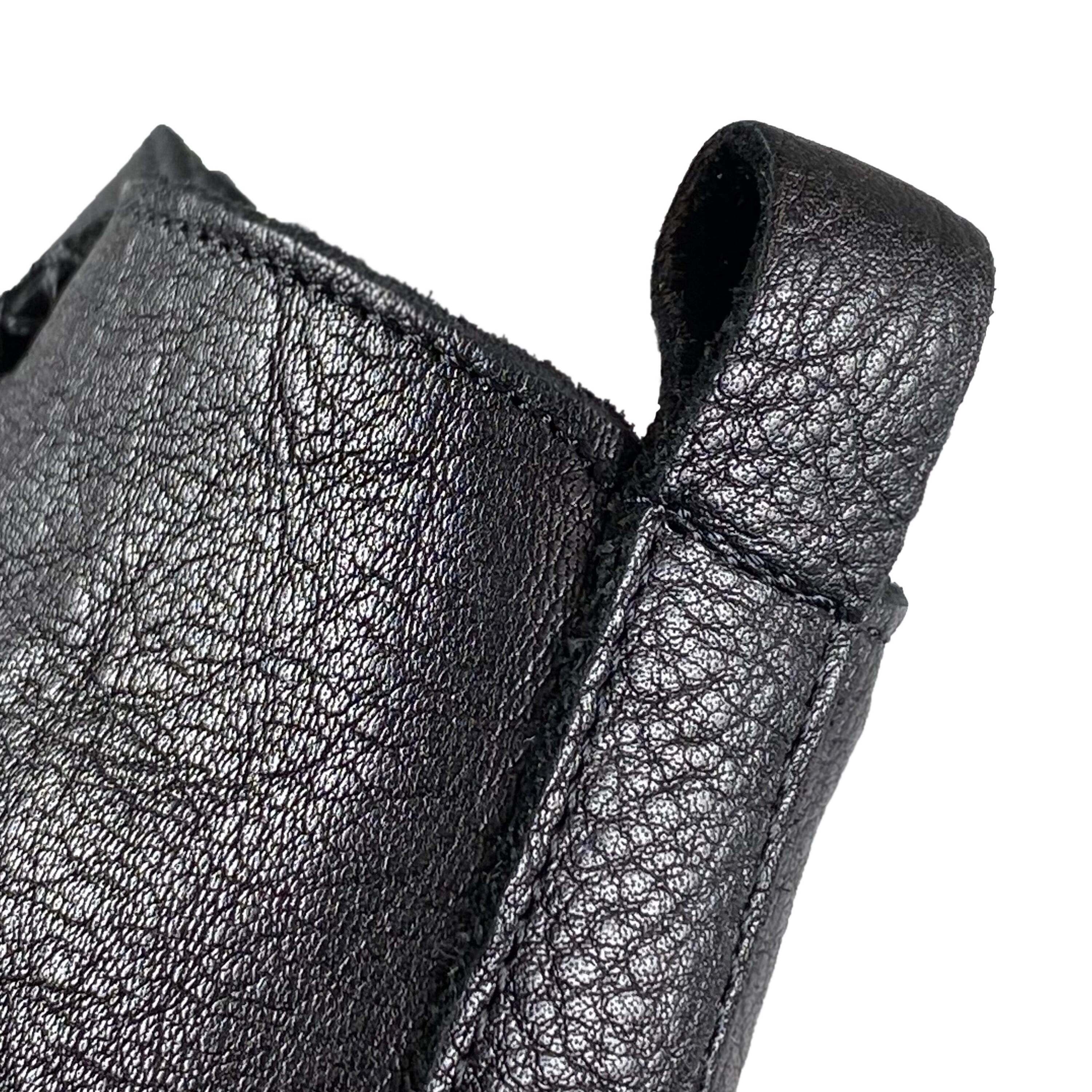 Detailansicht der Anziehschlaufe und des oberen Schaftrands einer schwarzen Lederstiefelette.
