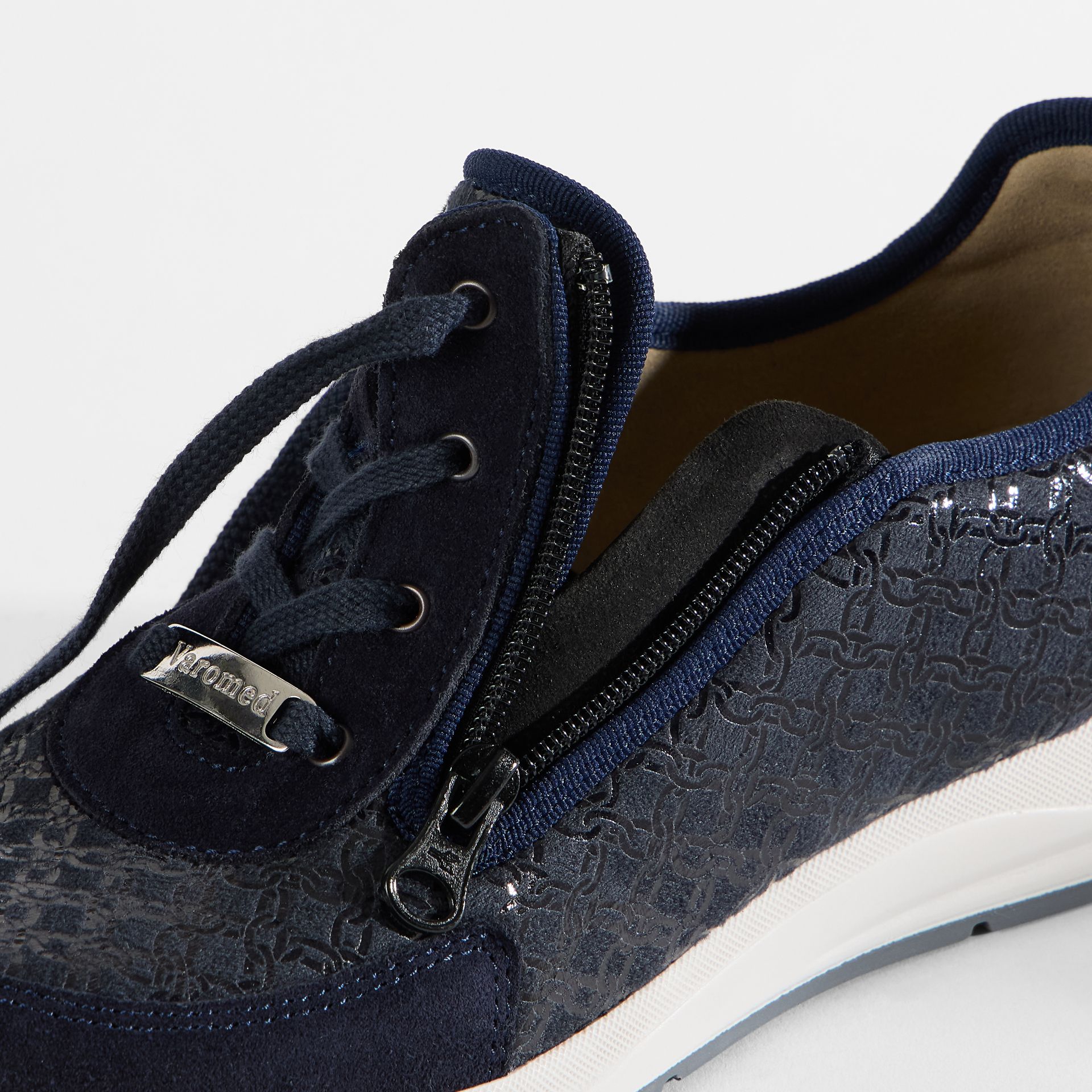 Dunkelblaue Sneaker mit Schnürung und Reißverschluss. Geprägtes Muster auf den Seiten.