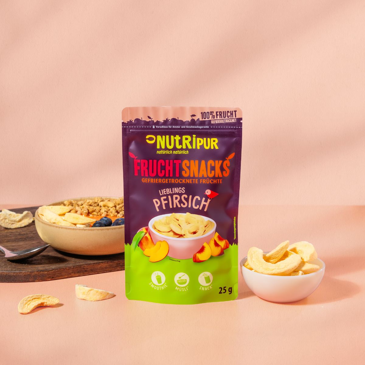 Verpackung mit gefriergetrockneten Pfirsich-Fruchtsnacks. Marke NutriPur. Schale mit Snacks und Müsli.