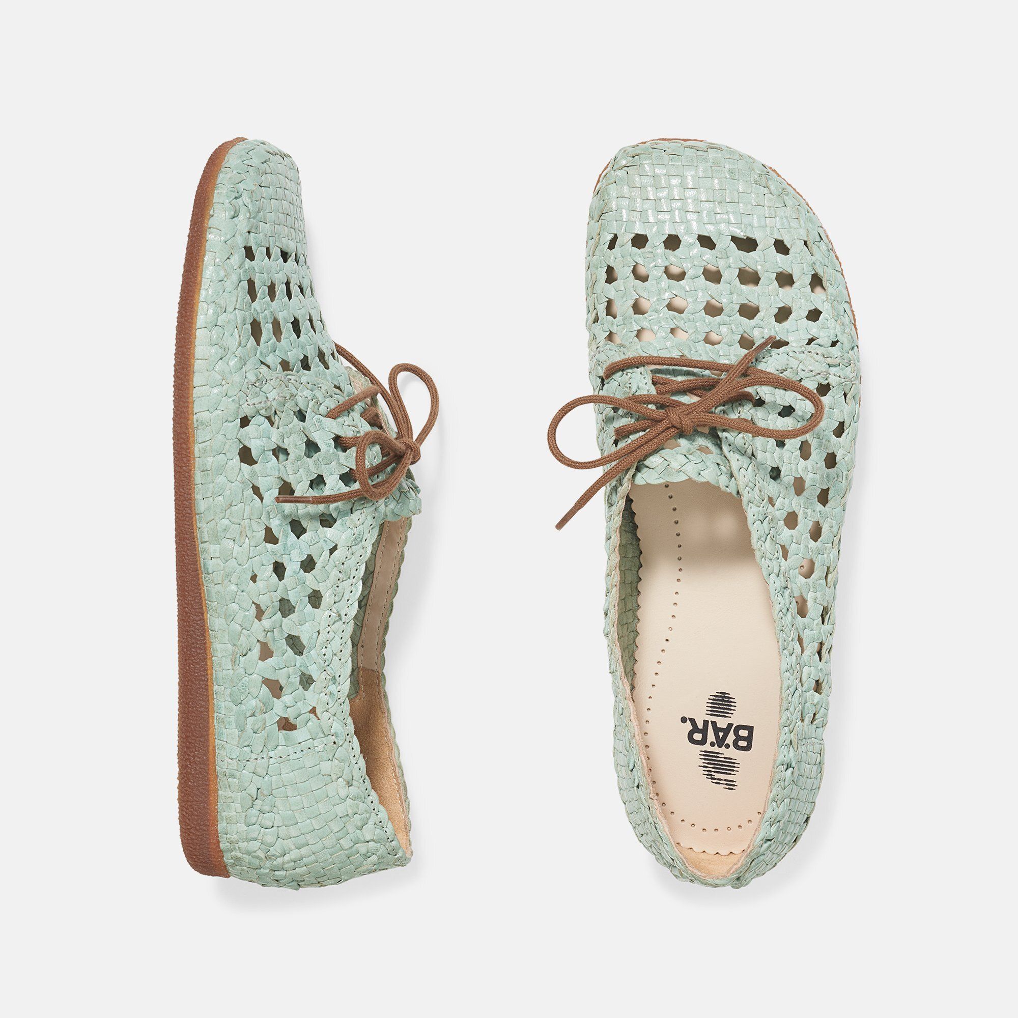 Zwei hellgrüne Damenschnürschuhe mit Lochmuster. Braune Schnürsenkel. Flache Sohle. Gewebtes Obermaterial. BÄR Logo.