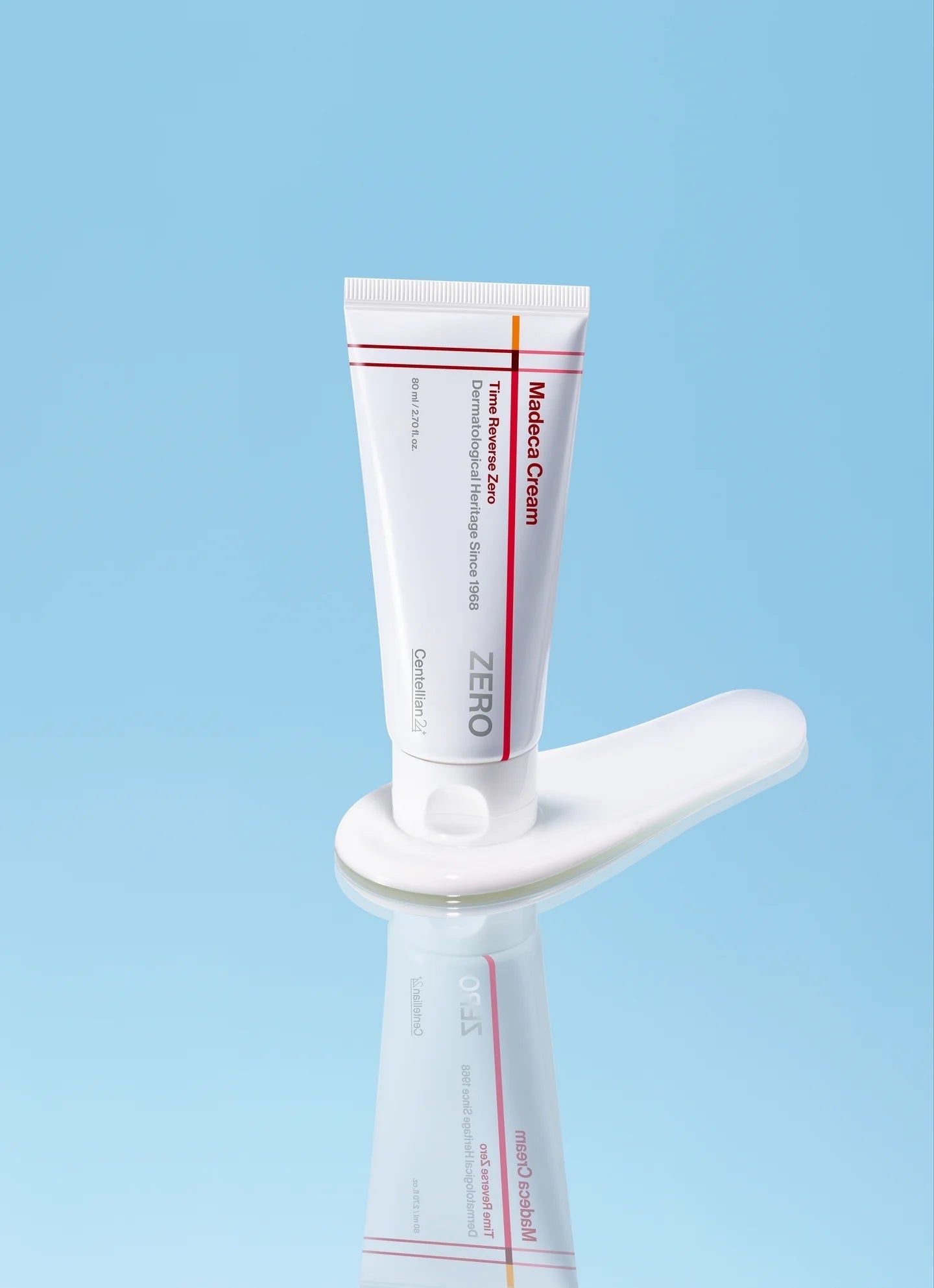 Eine Tube Madca-Creme auf einem weißen Löffel vor blauem Hintergrund.