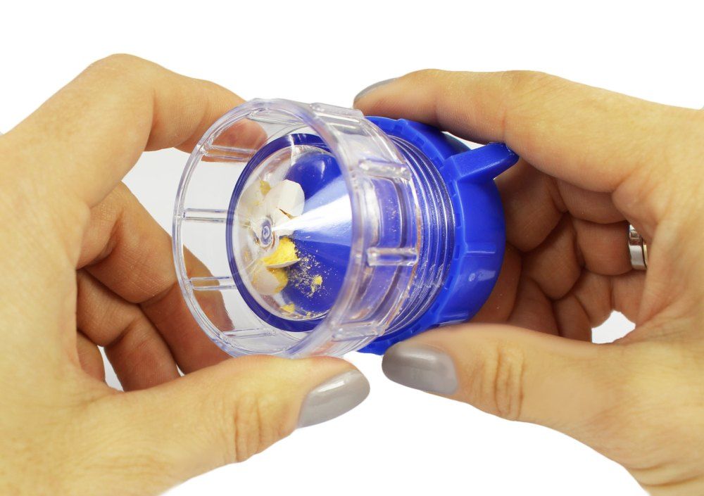 Tablettenmörser mit zermahlenen Tabletten. Hände halten das Gerät.