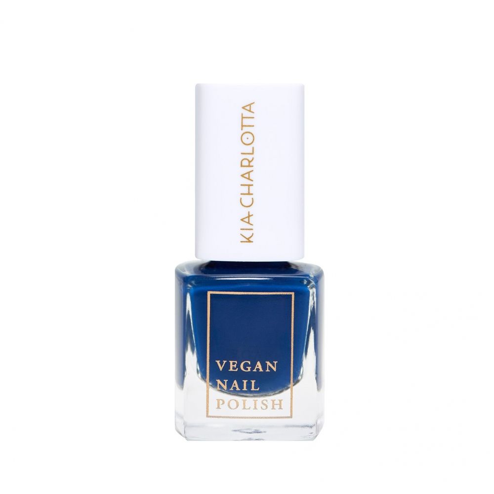 Nagellackflasche mit blauem Inhalt. Auf dem weißen Deckel steht "KIA-CHARLOTTA". Unter dem blauen Lack steht "VEGAN NAIL POLISH".